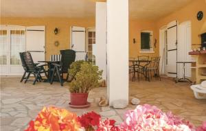 a patio with chairs and a table with flowers at Awesome Home In Argeliers With Wifi in Argeliers