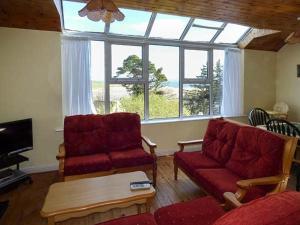 a living room with two couches and a large window at Number 12 in Mulranny