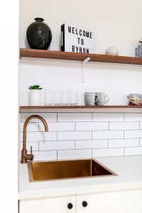 a kitchen sink with a welcome to swim sign on a shelf at Tallows Studio -Modern, tranquil, dog friendly,2 mins to the beach in Suffolk Park