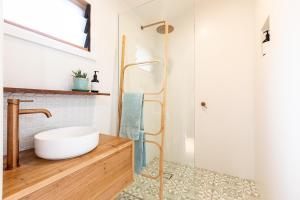 a bathroom with a white sink and a shower at Tallows Studio -Modern, tranquil, dog friendly,2 mins to the beach in Suffolk Park