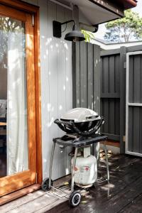 a grill sitting on a patio next to a house at Tallows Studio -Modern, tranquil, dog friendly,2 mins to the beach in Suffolk Park
