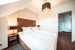 a bedroom with a large white bed and two lamps at Familienapartment Am Neumarkt lll in Dresden +10 photos