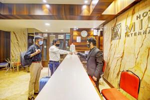 a group of men shaking hands at a table at Hotel Mina International in Mumbai