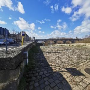 a stone wall with a bridge in the background at Chambre Monde Tout confort Saint-Marceau in Orléans