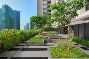 a garden on the roof of a building with trees at Citadines Sudirman Jakarta in Jakarta