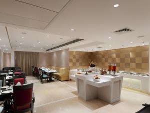 Un restaurante con mesas y sillas en una sala. en Inde Hotel Vista Woods Huda City Centre, Gurgaon, en Gurgaon