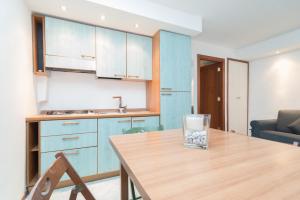a kitchen with a wooden table with a glass on it at Plebiscito Apartment in Naples