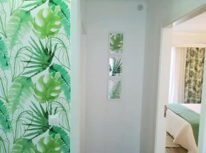 a bedroom with a green leafy wall at Alo Baía São Lourenço in Santa Bárbara