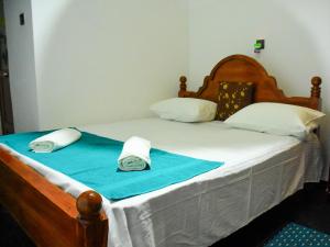 Una cama con dos toallas encima. en Relax Guest House Dambulla en Dambulla