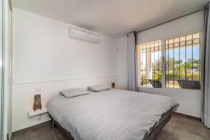biała sypialnia z dużym łóżkiem i oknem w obiekcie 2bed apartment in Miraflores w mieście Mijas
