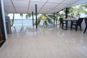 a dining room with a table and chairs and the ocean at Hotel Chivla Paradise in Malvan