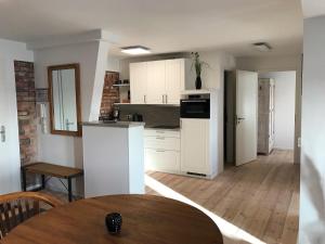 een keuken met witte kasten en een tafel in een kamer bij Speicher Residenz Barth E4 App 10 in Barth