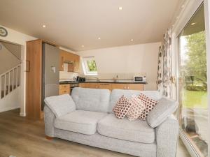 a living room with a couch and a kitchen at Lodge 22, Bodmin Holiday Park, Cornwall in Lanivet