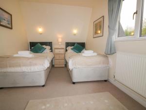 a bedroom with two beds and a window at Lodge 22, Bodmin Holiday Park, Cornwall in Lanivet