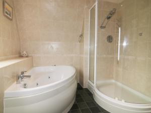 a bathroom with a white tub and a shower at Lodge 22, Bodmin Holiday Park, Cornwall in Lanivet +11 photos