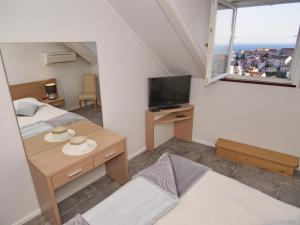 杜布羅夫尼克的住宿－Apartment & Rooms Ivušić，小房间设有两张床和电视
