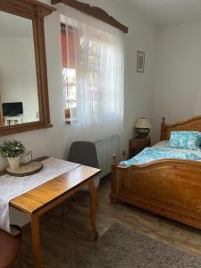 a bedroom with a bed and a table and a window at Penzion Hrádecký Dvůr in Pilsen