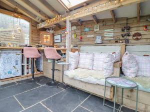 a room with a couch and two stools at Ty Gwyn Cottage in Llysfaen