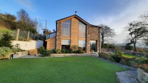 a house with a lawn in front of it at Ty Gwyn Cottage in Llysfaen