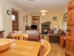 ein Wohnzimmer mit Sofa und Tisch in der Unterkunft Tanner Croft Cottage in Ambleside