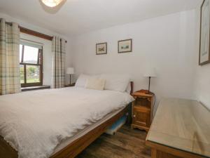 アンブルサイドにあるTanner Croft Cottageのベッドルーム(白いベッド1台、窓付)