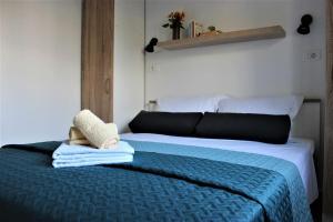 a bedroom with a bed with towels on it at Apartments Piscina-Green in Podstrana