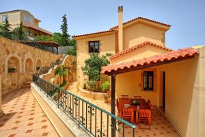 a balcony of a house with a table and chairs at Villa Sevi Grande by PosarelliVillas in Káto Vení