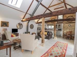 uma sala de estar com mobiliário branco e uma parede de tijolos em The Old Swill House em Chippenham