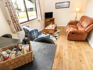 a living room with a couch and a table with a bottle of wine at Primrose Lodge in Saltburn-by-the-Sea