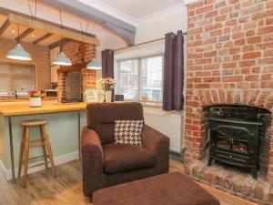 布里德靈頓的住宿－Ogle Cottage，客厅设有砖砌壁炉和椅子