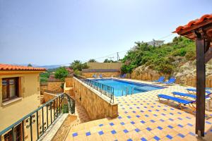 a swimming pool with blue chairs next to a house at Villa Sevi Grande by PosarelliVillas in Káto Vení