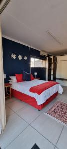 OlifantshoekにあるDe Anker Verblyfの赤と青の壁のベッドルーム1室(大型ベッド1台付)