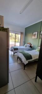 um quarto com 2 camas e uma janela em De Anker Verblyf em Olifantshoek