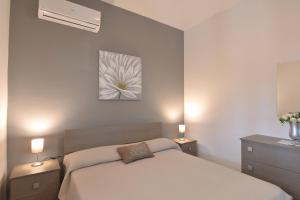 ein Schlafzimmer mit einem weißen Bett mit zwei Nachttischen und zwei Leuchten in der Unterkunft Villa Lucy in Case Monterosso