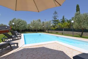 einen Pool mit Stühlen und einem Sonnenschirm in der Unterkunft Villa Lucy in Case Monterosso
