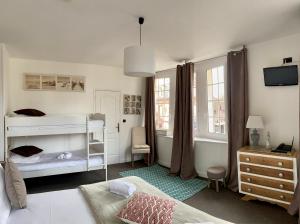 a bedroom with two bunk beds and a desk at Hotel Le Normand in Houlgate