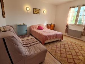 a bedroom with a bed and a couch in it at REF 020 Maison 5 chambres proche plage et Port du Crouesty à louer pour les vacances in Arzon