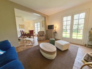 a living room with a blue couch and a table at REF 020 Maison 5 chambres proche plage et Port du Crouesty à louer pour les vacances in Arzon