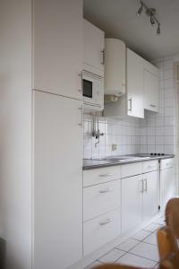 cocina blanca con armarios blancos y nevera en Appartement Walvis nr. 16, en Vrouwenpolder