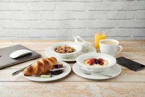 a table with two plates of breakfast food and a laptop at Green Lodge, Wirral by Marston's Inns in Hoylake