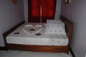 卡拉圖的住宿－Beautiful & Stylish 2-Bedroom Apartment in Karatu，一间卧室配有一张带心形枕头的床