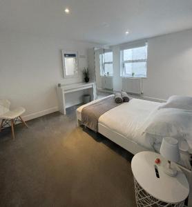a bedroom with a large bed and a table at Prosper House Apartments in Norwich