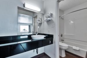 a bathroom with a sink and a toilet and a mirror at Motel 6-Irving, TX - Dallas in Irving
