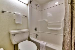 a small bathroom with a toilet and a bath tub at Motel 6-Irving, TX - Dallas in Irving