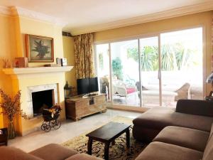 salon z kanapą i kominkiem w obiekcie Beautiful, Bright and Spacious Duplex in Marbella w mieście Estepona