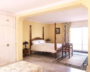 sypialnia z łóżkiem z baldachimem i oknem w obiekcie Beautiful, Bright and Spacious Duplex in Marbella w mieście Estepona +37 zdjęć