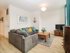 - un salon avec un canapé et une télévision dans l'établissement Quayside Lookout, à Brixham