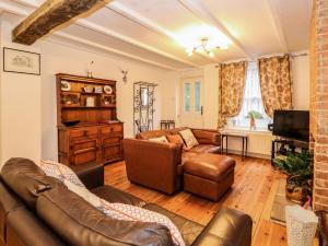 un salon avec un canapé et une table dans l'établissement Duck Cottage, à Snettisham