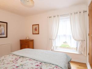 une chambre avec un lit et une fenêtre dans l'établissement Duck Cottage, à Snettisham