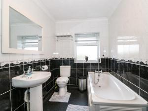 une salle de bains avec lavabo, baignoire et toilettes dans l'établissement Duck Cottage, à Snettisham 22 autres photos
